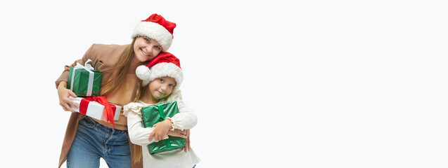 Christmas family. Cute young mother and daughter in santa Claus caps holding colorful gift boxes on white. Preparing for New Year's holidays in Italy