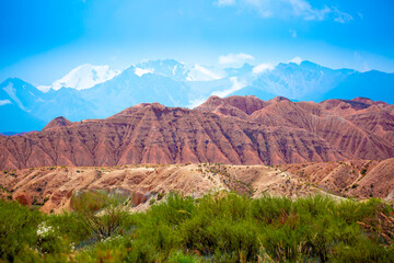 Naklejka premium Natural unusual landscape of red rocks against the backdrop of blue mountains. The extraordinary beauty of nature is similar to the Martian landscape. Amazingly beautiful landscape.