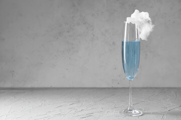 Glass with tasty cotton candy cocktail on grey background