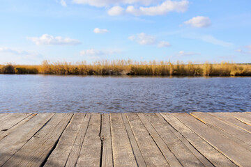 Closeup view of wooden pier near river on sunny autumn day