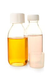 Bottles of cough syrup and cup on white background