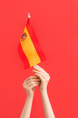 Woman with flag of Spain on red background