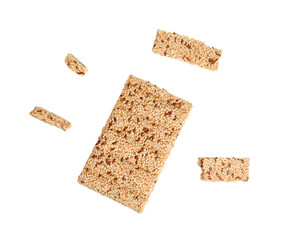 Whole and crushed sesame kozinaki bars on white background