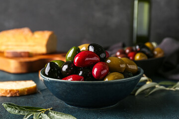 Bowl with different delicious olives on table, closeup
