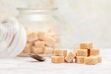 Cubes of brown sugar piled on a light background