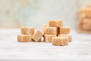 Cubes of brown sugar piled on a light background