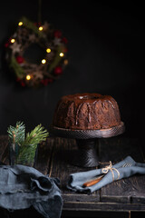 Christmas chocolate cake and decoration on a wooden table. Close up. Copy space. Dark and moody