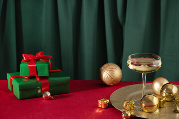 Merry Christmas and Happy New Year. Glass of champagne with golden Christmas ornaments and Christmas presents.