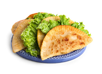 Plate with tasty chebureks and lettuce on white background