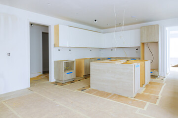 Installation of white kitchen cabinets in a newly constructed house