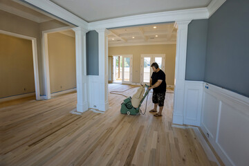 The process of grinding wooden parquet floor with use of floor sander in newly constructed house using grinding machine
