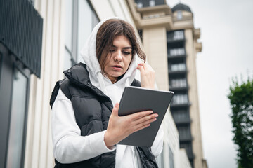 Business young woman with a tablet on the background of the building.