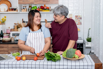 Asian couples, fat man and woman are happiness together, which do joint activities in the family by cooking in the kitchen, to relationship in Asian family and clean food concept. - obrazy, fototapety, plakaty