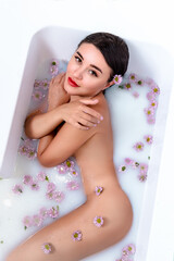 Naklejka premium the girl lies in bathtub . white water. girl in flowers.