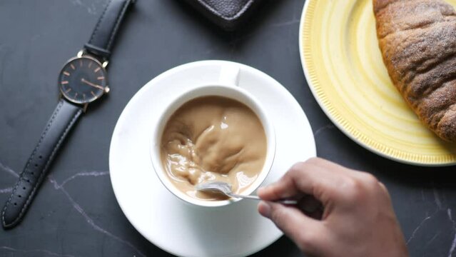 Person Hand Stirring Coffee With Spoon.