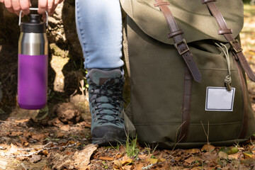 military backpack, thermos of water and hiking boots
