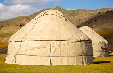 Yurt. National old house of the peoples of Kyrgyzstan and Asian countries. national housing. Yurts on the background of green meadows and highlands. Yurt camp for tourists.