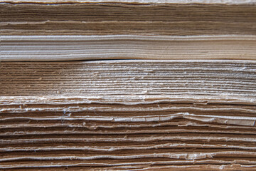 Macro closeup antique books in a stack showing ragged side of text blocks, nobody