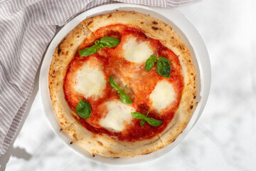Margarita or margherita pizza with heart shaped mozzarella cheese on white background, top view