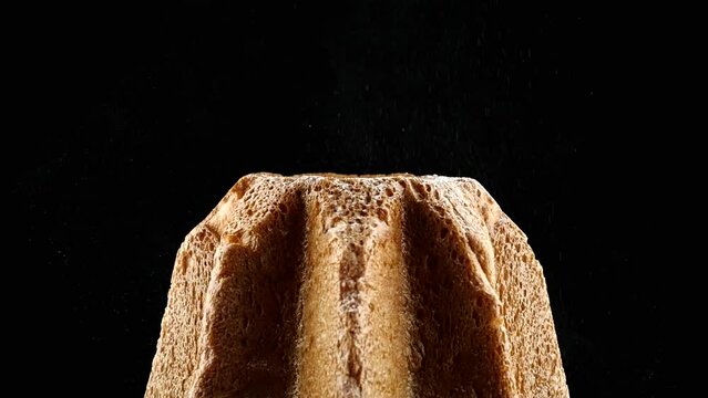 Close up of a Pandoro. The powdered sugar falls in slow motion on Pandora, creating the Christmas magic. 