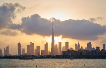 sun coming out from behind clouds and Dubai skyline