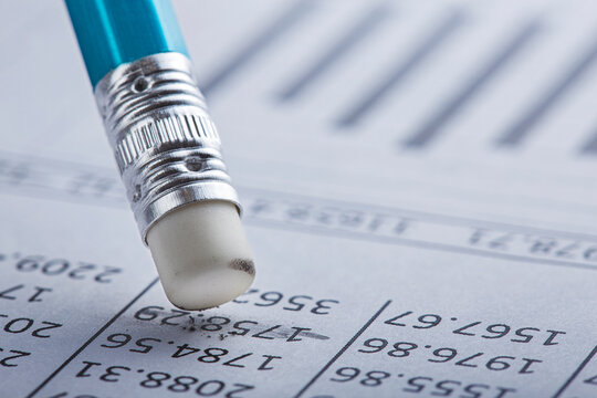 Accounting document with eraser erases blots in the document and checking financial chart. Concept of banking, financial report and financial audit.