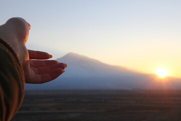 Fototapeta na wymiar Person watching sunset. Hand showing sunset. Beautiful view.