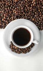 Cup of coffee and coffee beans, flat lay.