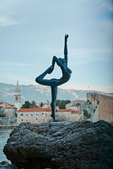 statue of a ballerina on top of the rock in old city of budva