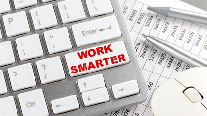 WORK SMARTER text on a keyboard wirh chart and pencil
