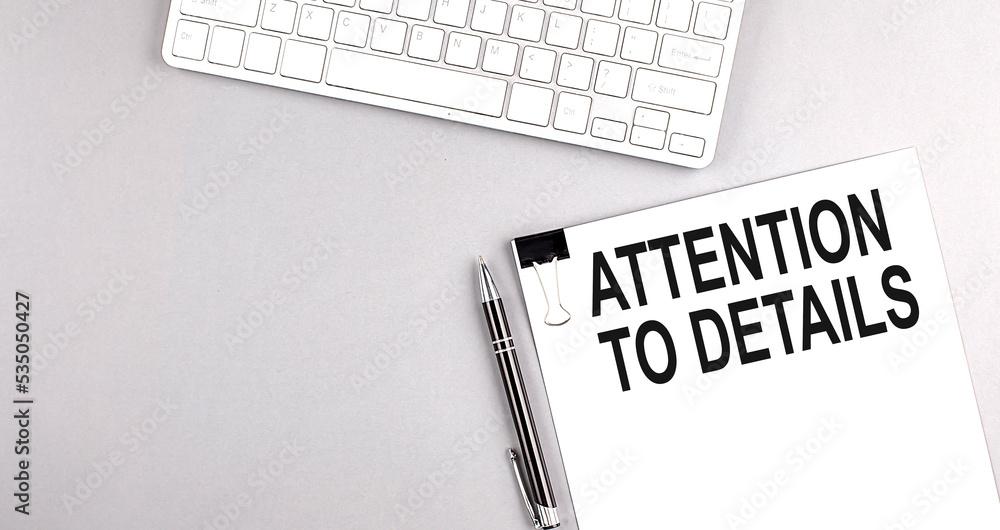 Poster attention to details text on paper with keyboard on grey background