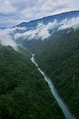 clouds over the river in canyon surrounded by forest