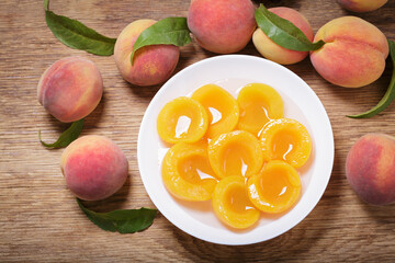 Naklejka na ściany i meble bowl of canned peaches and fresh fruits, top view