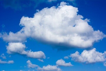 Naklejka na ściany i meble Fluffy clouds on vibrant blue sky