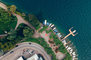 Lugano city park entrance with boats and the lake of Ticino and trees and flowers taken with a...