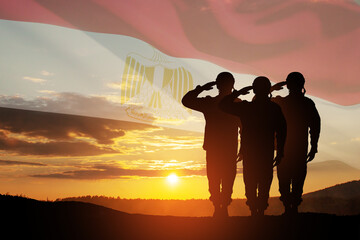 Double exposure of silhouettes of a soliders and the sunset or the sunrise against flag of Egypt....