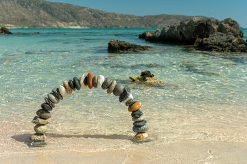Stone arch made of pebbles in the sea water.