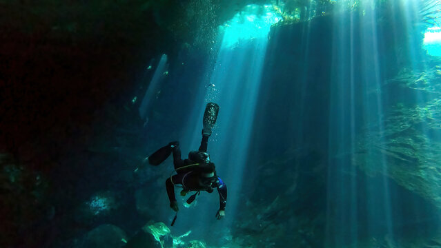 scuba diver exploring chac-mool cenote near cancun mexico