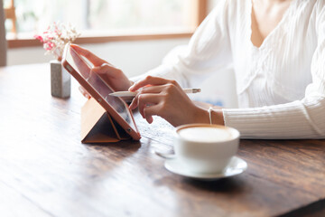 business woman drinking coffee and working on wooden table at home Using a laptop and computer to...