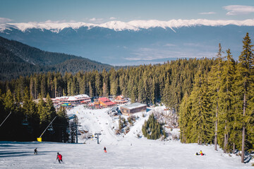 Winter landscape with panorama of Bansko above the clouds. Famous ski resort in Bulgaria. View of the ski slopes and the Pirin Mountains