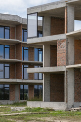 Construction of a red brick apartment building with large modern windows in Ukraine
