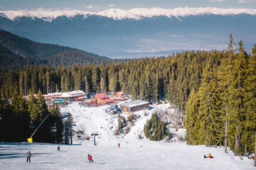 Winter landscape with panorama of Bansko above the clouds. Famous ski resort in Bulgaria. View of the ski slopes and the Pirin Mountains