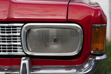 A classic old American car. Retro car. Red retro car headlight.