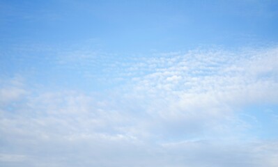 Beautiful, white air clouds in a clear blue sky are gentle as fluffs.  Beauty of nature, beautiful day.  Close-up.