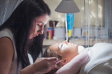 Woman master in salon making eyelash extension