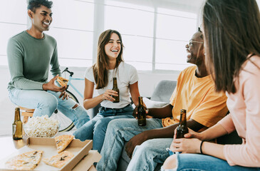 Group of friends watching tv and eating pizza - Multiracial cheerful young people having weekend home party together - Happy students having fun in university rooms - Youth lifestyle and food concept