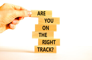 Right track symbol. Concept words Are you on the right track on wooden blocks on a beautiful white table white background. Businessman hand. Business motivational and right track concept.