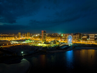 Fototapeta na wymiar Panorama night city Kazan. View of the new quarters of new buildings and the Ferris wheel in the evening illumination
