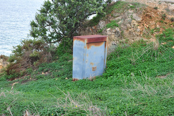 Old Rusty Metal Cabinet on Grass of Exposed Seaside Cliff Top 