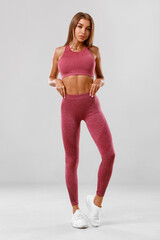 Sexy fitness woman. Beautiful athletic girl, isolated on the gray background